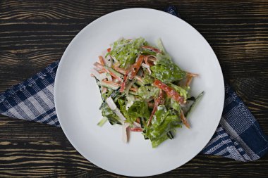 Diyet gıda, imitasyon yengeç sopa, soya sosu ve Japon susam ile taze sebze salatası. Şeritler halinde kesin. Koyu ahşap arka plan. Yukarıdan görüntülemek.