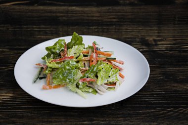 Diyet gıda, imitasyon yengeç sopa, soya sosu ve Japon susam ile taze sebze salatası. Şeritler halinde kesin. Koyu ahşap arka plan. Yukarıdan görüntülemek.