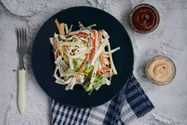 Diätetisches Essen, frischer Gemüsesalat mit imitierter Krabbenstange, gewürzt mit Sojasauce und japanischem Sesam. in Streifen schneiden. Blick von oben — Stockfoto