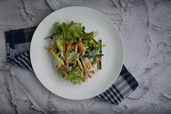 Diätetisches Essen, frischer Gemüsesalat mit imitierter Krabbenstange, gewürzt mit Sojasauce und japanischem Sesam. in Streifen schneiden. Blick von oben — Stockfoto