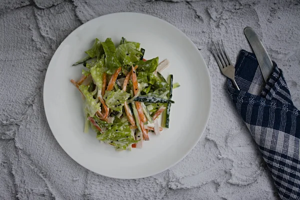 Diätetisches Essen, frischer Gemüsesalat mit imitierter Krabbenstange, gewürzt mit Sojasauce und japanischem Sesam. in Streifen geschnitten. — Stockfoto