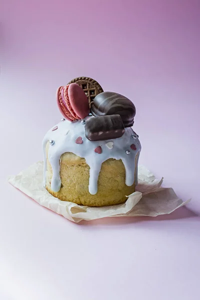 Pasqua, torta di Pasqua decorata con cioccolato e amaretti. Kulich tradizionale, pane pasquale. Vacanza primaverile in memoria della risurrezione di Cristo. Sfondo rosa . — Foto Stock