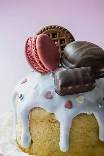 Påsk, påsk tårta dekorerad med choklad och mandelbiskvier. Traditionella Kulich, påsk bröd. Spring semester till minne av Kristi uppståndelse. Rosa bakgrund. — Stockfoto