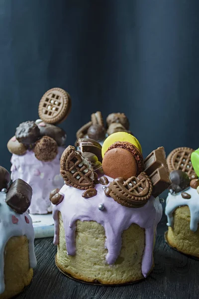 Pascua, pasteles de Pascua están decorados con chocolate y macarrones. Tradicional Kulich, Pan de Pascua. Vacaciones de primavera en memoria de la resurrección de Cristo. Fondo oscuro . — Foto de Stock