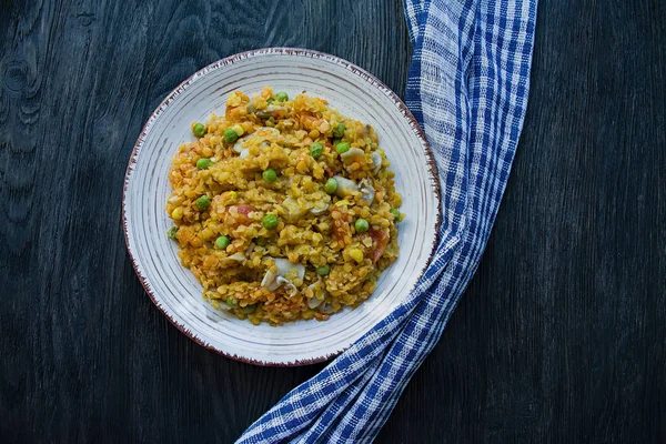 Lentil porridge with vegetables and herbs. Healthy lifestyle. Dietary menu. Dark wooden background. View from above.