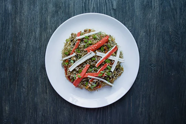 Asiatische Küche. Fenchosalat gebraten mit Gemüse, dekoriert mit Gemüse und Krabbenstangen. Richtige Ernährung. Gesunde Ernährung. Blick von oben. dunkler Holzhintergrund. — Stockfoto