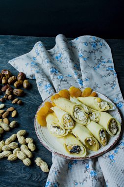 Süzme peynir, Erik, Kuru kayısı ve kuru üzüm ile krep. Yan görünüm. Koyu ahşap arka plan.
