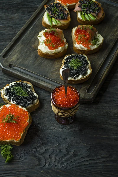 Caviar vermelho em cerâmica. Close-up. Fundo de madeira escuro . — Fotografia de Stock