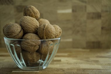 Ahşap bir arka planda cam kase ceviz. Yan görünüm.