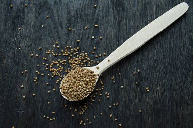 Karabuğday, koyu ahşap bir arka planda ahşap bir kaşık içinde kasık. Yukarıdan görüntüle.