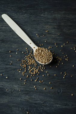 Karabuğday, koyu ahşap bir arka planda ahşap bir kaşık içinde kasık. Yan görünüm.