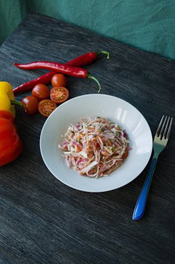 Beyaz lahana salatası, havuç ve biber. Yeşillik ve sebzelerle dekore edilmiştir. Vejetaryen yemek. Doğru beslenme. Koyu ahşap arka plan.