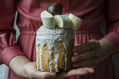 Paskalya, Paskalya pastası çikolata ve marshmallow ile dekore edilmiştir. Kulich kadın ellerinde. Geleneksel Kulich, Paskalya Ekmeği. Mesih'in dirilişi anısına Bahar tatili.