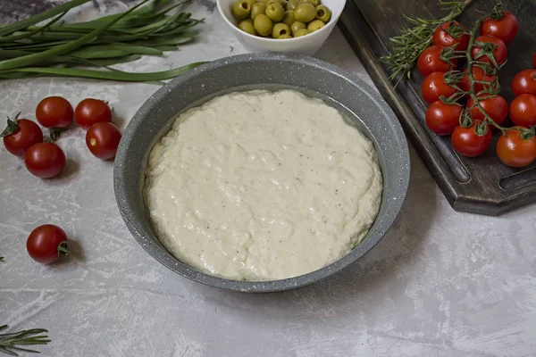 Традиционная итальянская фокачча с помидорами, оливками и розмарином. Процесс приготовления фокаччи, ингредиенты. Фокачча . — стоковое фото