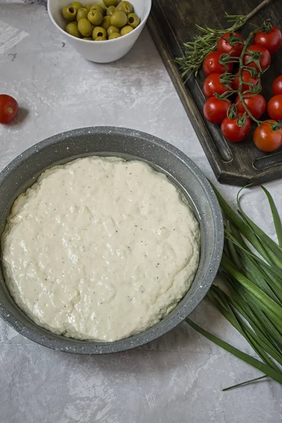 Traditionelle italienische Focaccia mit Tomaten, Oliven und Rosmarin. Focaccia Kochen Prozess, Zutaten. Focaccia-Teig. — Stockfoto