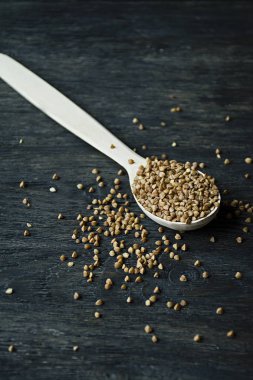 Karabuğday, koyu ahşap bir arka planda ahşap bir kaşık içinde kasık. Yan görünüm.