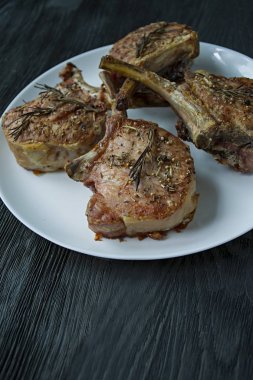 Baharat ve otlar ile domuz kaburga ızgara biftek. Yan görünüm. Koyu ahşap arka plan.