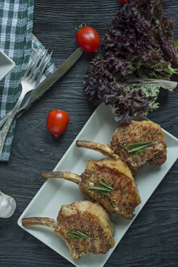 Baharat ve otlar ile domuz kaburga ızgara biftek. Kemikli biftek. Yukarıdan görüntüleyin. Koyu ahşap arka plan.