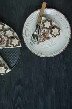 Süzme peynirli kek (pişmiş cheesecake olmadan) kurabiye ve koyu ahşap arka plan üzerinde rendelenmiş siyah çikolata ile dekore edilmiştir. Metin için alan.