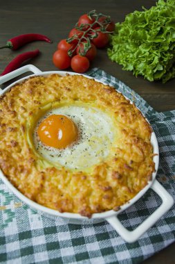 Bolonezli patates güveci. Yumurtalı fırında patates güveci ve rendelenmiş peynir seramik oval kabartma çarşafında. Ahşap arka plan. Yukarıdan görüntüle.