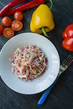 Beyaz lahana salatası, havuç ve biber. Yeşillik ve sebzelerle dekore edilmiştir. Vejetaryen yemek. Doğru beslenme. Koyu ahşap arka plan.