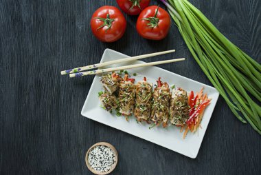 Yeşil, havuç dilimleri, karanlık bir kesme tahtasında biber ile taze tavuk göğsü ile Rolls. Sağlıklı ev yapımı gıda kavramı. Koyu ahşap arka plan.