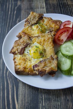 Koyu ahşap arka plan üzerinde yumurta, sebze ve pastırma ile ızgara sandviç. Lezzetli kahvaltı.