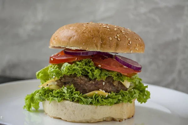 Świeży domowy Burger na białej płytce. Niezdrowe jedzenie. — Zdjęcie stockowe