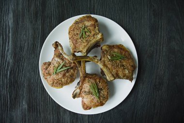 Baharat ve otlar ile domuz kaburga ızgara biftekler. Kemik bifteği. Yan görünüm. Koyu ahşap arka plan.