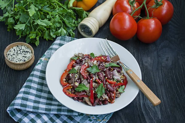 Salat aus Rindfleisch und Bohnen, Paprika. Salat "Tiflis", traditionelle georgische Küche. dunkler Holzhintergrund. — Stockfoto