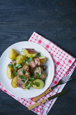 Et ve sebze ile fırında genç patates. Koyu ahşap arka plan.