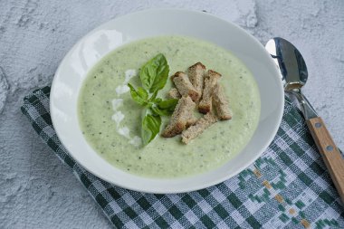 Hafif bir arka plan üzerinde kabak püresi çorbası ve fesleğen.