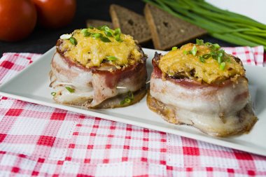 Pastırma dilimleri ile pişmiş kıyılmış peynir, yeşillik. Koyu ahşap arka plan.