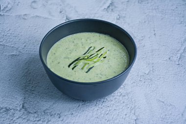 Hafif bir arka plan üzerinde kabak püresi çorbası ve fesleğen.