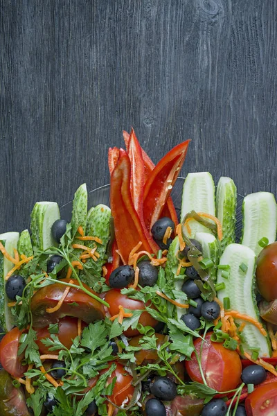 Vegetais frescos variados fecham. Preparado para salada. Pepino, tomate, pimentão, verduras, azeitonas. Vista de cima. Fundo de madeira escuro . — Fotografia de Stock