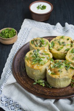 Kabak kıyma, sebze ile doldurulmuş ve sert peynir serpilir. Yan görünüm.