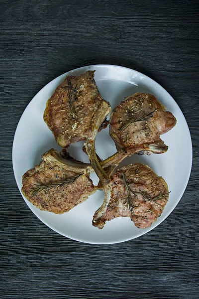 Steaks grillés de côtes de porc avec des épices et des herbes. Vue du super fond en bois sombre . — Photo