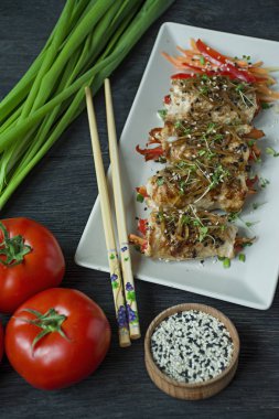 Yeşil, havuç dilimleri, karanlık bir kesme tahtasında biber ile taze tavuk göğsü ile Rolls. Sağlıklı ev yapımı gıda kavramı. Koyu ahşap arka plan.