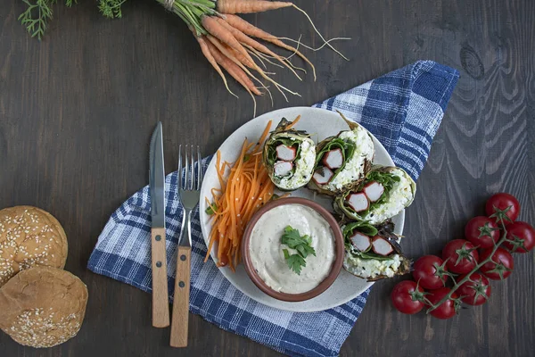 Zucchini roll with crab sticks, eggs and spinach. Delicious appetizer served on a round plate with sauce and fresh vegetables and herbs. View from above. — Stock Photo, Image