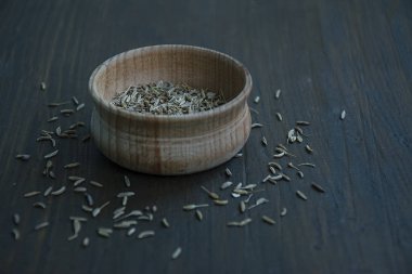 Ahşap bir çanak içinde Kimyon tohumları. Koyu ahşap arka plan. Yukarıdan görüntüle. Close.