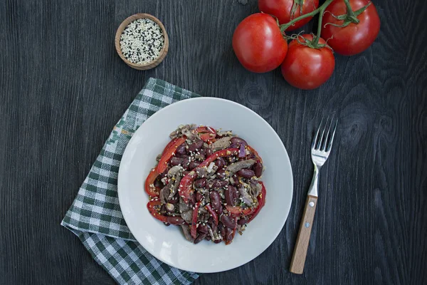 Salat aus Rindfleisch und Bohnen, Paprika. Salat "Tiflis", traditionelle georgische Küche. dunkler Holzhintergrund. — Stockfoto