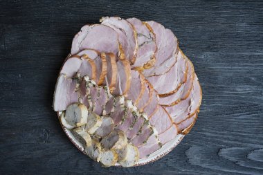 Bir seçim ile et tabağı - tatil masasında sosis ve kürlenmiş et kesme. Koyu ahşap arka plan.