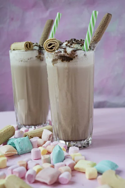 Milkshake avec crème glacée et crème fouettée, guimauves, biscuits, gaufres, servi dans une tasse en verre. Fond en bois foncé. Espace pour le texte . — Photo