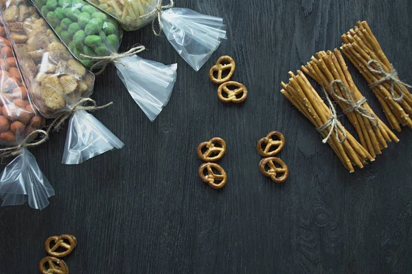 Snacks for beer, nuts and crackers. Oktober Fest. Beer snacks. Dark wooden background. Space for text.