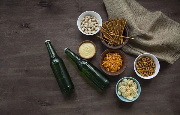 Cerveza Oktoberfest con pretzels y varios tipos de aperitivos salados. Snacks de cerveza. Fondo de madera. Vista desde arriba. Lugar para el texto . —  Fotos de Stock