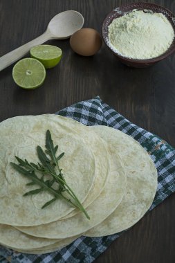 Taco veya burrito için düz kek. Taco yapmak için pide. Koyu ahşap arka plan.