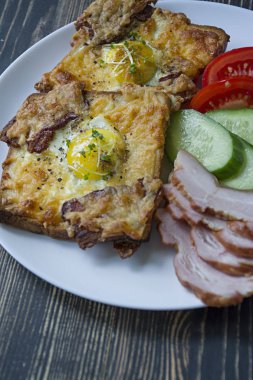 Koyu ahşap arka plan üzerinde yumurta, sebze ve pastırma ile ızgara sandviç. Lezzetli kahvaltı.