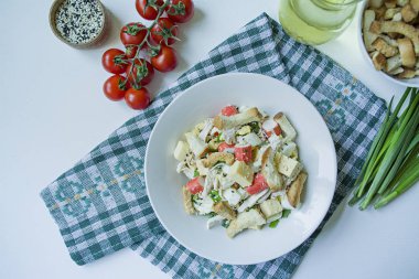 Kraker, yengeç çubukları, tavuk fileto, taze otlar ve mayonez tereyağı ile deneyimli sert peynir ile salata beyaz bir plaka servis. Mayonez salatası. Yukarıdan görüntüle. Beyaz arka plan.