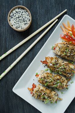 Yeşil, havuç dilimleri, karanlık bir kesme tahtasında biber ile taze tavuk göğsü ile Rolls. Sağlıklı ev yapımı gıda kavramı. Koyu ahşap arka plan.