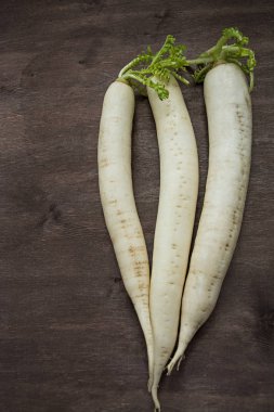 Turp daikon ahşap bir arka plan üzerinde. Metin için yer.